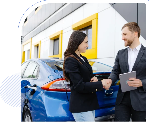 Man and woman shaking hands in front of a blue electric car, parked near a modern building. Woman holds car keys; man holds a tablet. Both are smiling.